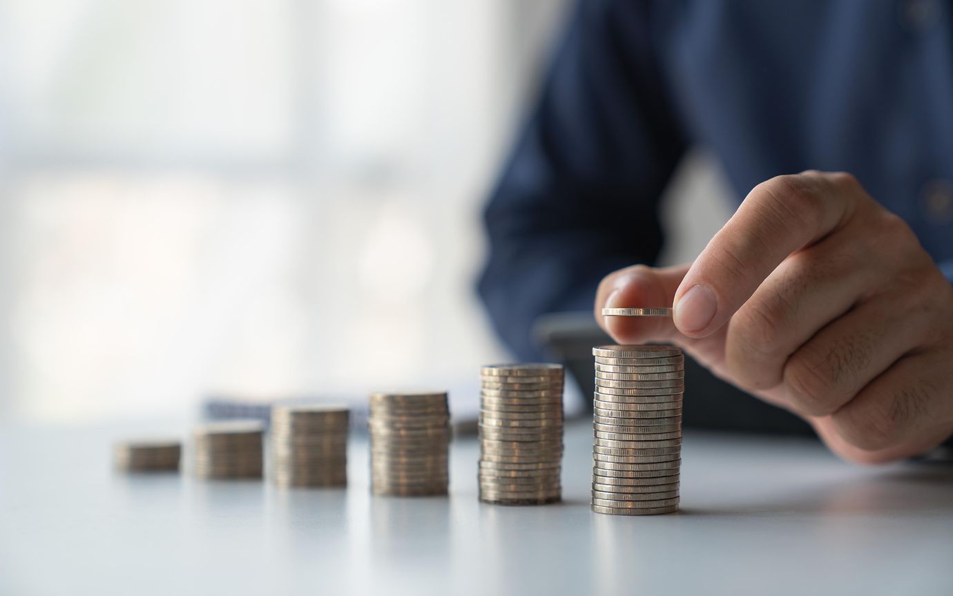 Male hand stacking coins.