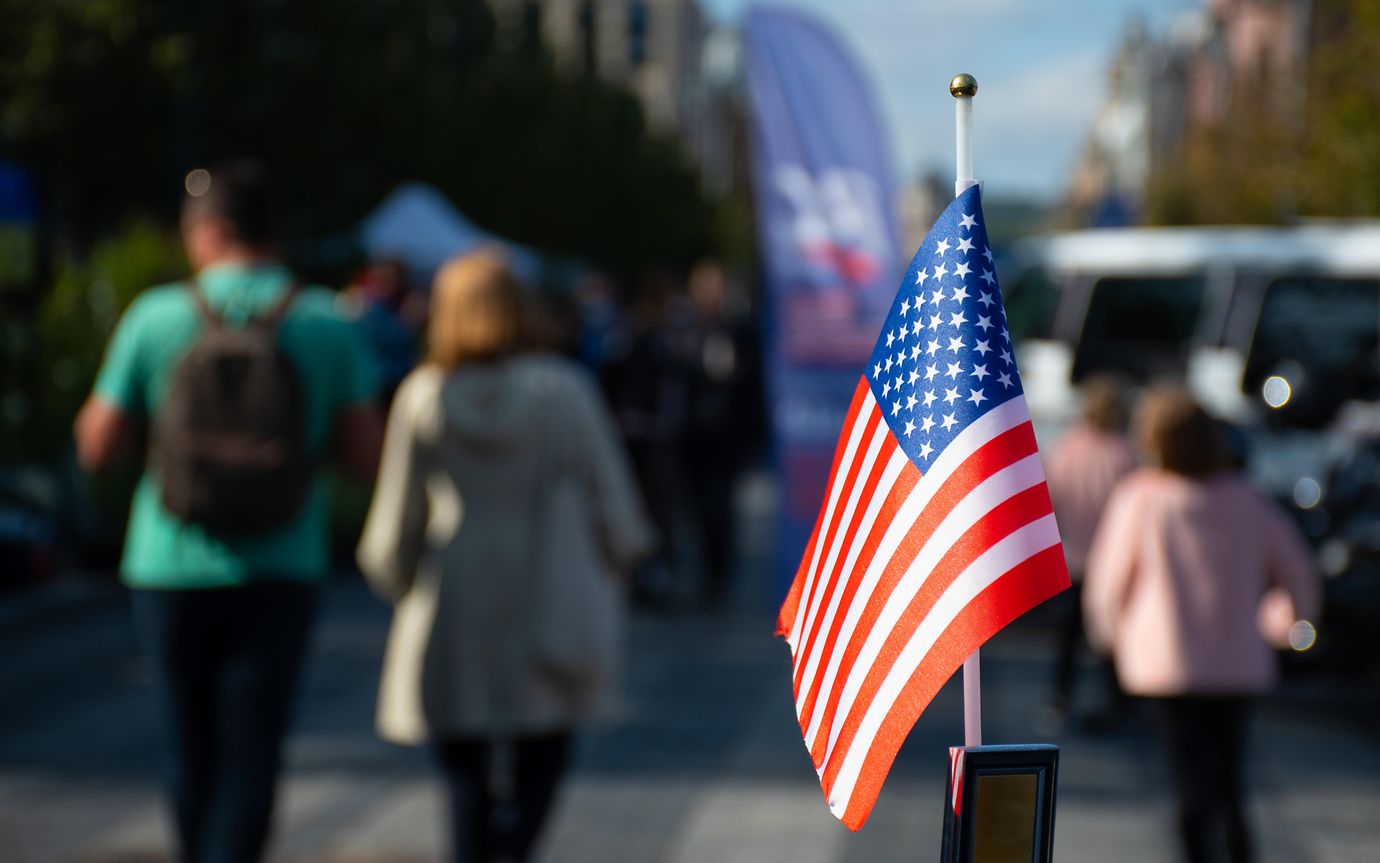 American flag set against blurred background of people